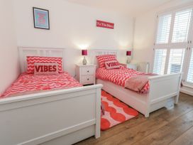 A bedroom with two beds and a bedside table at Betty's Buoy in Weymouth