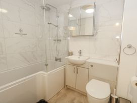 A bathroom with a bathtub, shower, sink, and toilet at Betty's Buoy in Weymouth