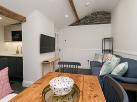 An open plan living area with a sofa and dining table at Pippins in Ambleside