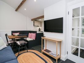 A living room with a sofa, table, and television at Pippins in Ambleside