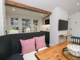 A kitchen with a table, sofa, and television at Pippins in Ambleside