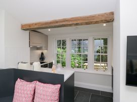 A kitchen with cabinets and window at Pippins in Ambleside