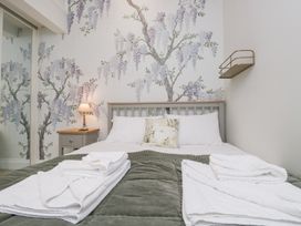 A bedroom with a bed and wall art at Pippins Ambleside
