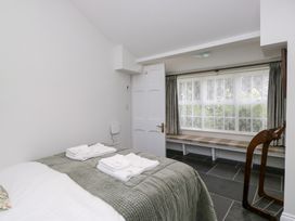 A bedroom with a bed and window seat at Pippins in Ambleside
