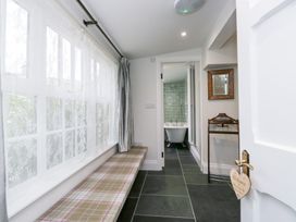 A hallway with a bench and access to a bathroom at Pippins Ambleside