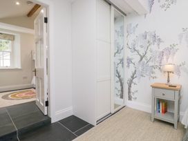 A bedroom with a wardrobe and side table at Pippins in Ambleside