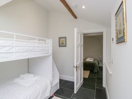 A bedroom with a bunk bed and a door leading to another room at Pippins in Ambleside