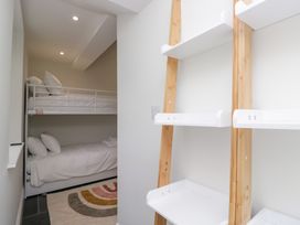 A bedroom with a bunk bed and shelves at Pippins in Ambleside