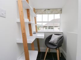 A study with a ladder shelf and a chair at Pippins in Ambleside