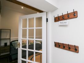 An entrance with coat hooks and a welcome sign at Pippins in Ambleside