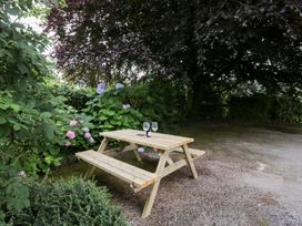 A garden with a picnic table and glasses at Pippins in Ambleside