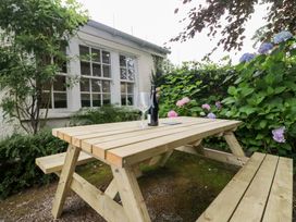 A garden with a wooden table and a bottle on it at Pippins in Ambleside