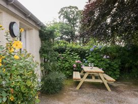 A picnic table with glasses surrounded by flowers at Pippins in Ambleside