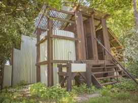 An outdoor wooden structure with corrugated metal walls a sink a small staircase and surrounding greenery at Brandon House Farm Yurt Brandon Parva near Mattishall