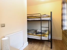 A bedroom with a black metal bunk bed and folded towels near a window at Rabbit Warren Lodge in Snettisham