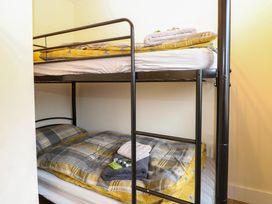 A bunk bed with folded towels and toiletries on the bottom bed at Rabbit Warren Lodge in Snettisham