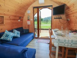 A living room with a sofa and dining table at Ty Twt Teifi in Tregaron