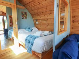 A bedroom with a bed and sofa at Ty Twt Teifi in Tregaron