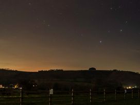 A view of stars and hills with lights at Ty Twt Teifi in Tregaron