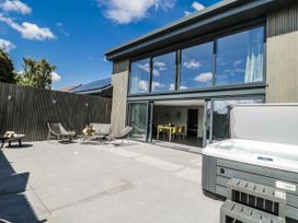 An outdoor patio area with a hot tub and seating at Number 7 in Bishop Sutton