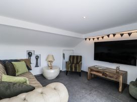 A snug with a sofa, armchair, and television at Number 7, Bishop Sutton
