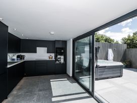 A kitchen with cabinets and a hot tub at Number 7 in Bishop Sutton