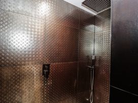 A shower area with metal wall panels at Number 7 Bishop Sutton