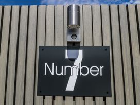 A number sign and a light fixture at Number 7 in Bishop Sutton