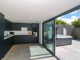 A kitchen with dark cabinets and a hot tub outside at Number 7 Bishop Sutton