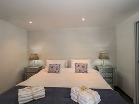 A bedroom with a bed and nightstands at Number 7 in Bishop Sutton