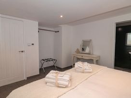 A bedroom with a bed, towels on top and a mirror at Number 7 Bishop Sutton
