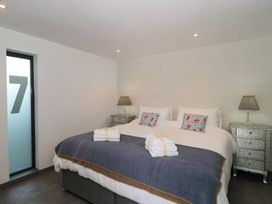 A bedroom featuring a bed with towels and bedside lamps at Number 7, Bishop Sutton