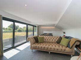 A living room with a sofa and large windows at Number 7 in Bishop Sutton