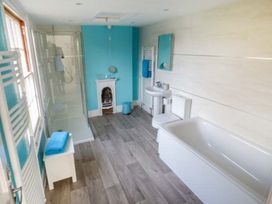 A bathroom with a bathtub toilet sink shower and towel racks at 1 Willow Cottage in Upton Upon Severn