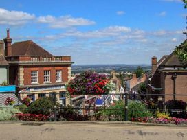 A street view with brick buildings shops and hanging flower baskets at 1 Willow Cottage in Upton Upon Severn