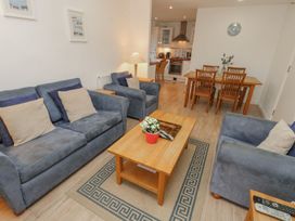 A living room with blue sofas and a wooden coffee table next to a dining table and kitchen at Pierpont D1 Norton near Yarmouth