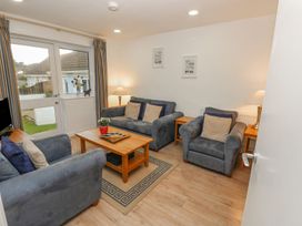 A living room with gray sofas a wooden coffee table and lamps at Pierpont D1 in Norton near Yarmouth