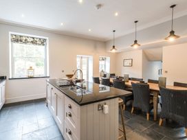 A kitchen with an island countertop and a dining table with chairs at Tan Llan in Llanelltyd near Dolgellau