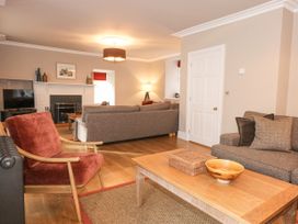 A living room with sofas a wooden coffee table and a fireplace at Tan Llan in Llanelltyd near Dolgellau