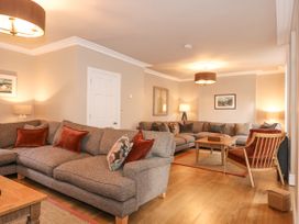 A living room with two gray sofas a wooden armchair and a coffee table at Tan Llan in Llanelltyd near Dolgellau