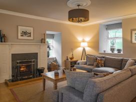 A living room with a fireplace and sofa at Tan Llan in Llanelltyd near Dolgellau