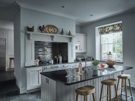A kitchen with a countertop island and stools at Tan Llan in Llanelltyd near Dolgellau