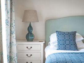 A bedroom with a bedside table and lamp at Tan Llan in Llanelltyd near Dolgellau