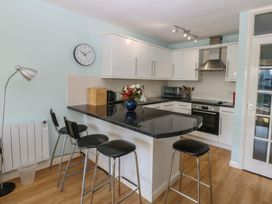 A kitchen with a countertop and bar stools at 1 Oakley Wharf Porthmadog