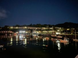 A harbor with boats and lights on the water at River's Edge Penthouse in Porthmadog