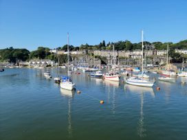 A view of boats in the harbor with houses on the hillside at River's Edge Penthouse in Porthmadog