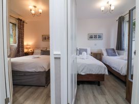 Two bedrooms each with beds bedside tables and curtains at Cove View in Ilfracombe