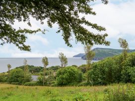 A coastal landscape with trees hills and water at Cove View Ilfracombe