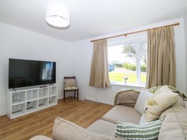 A living room with a television and sofa at 20 Gwelfor Estate in Cemaes Bay