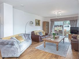 A living room with two sofas and a wooden coffee table with flowers on it at Cilfan in Llanrwst